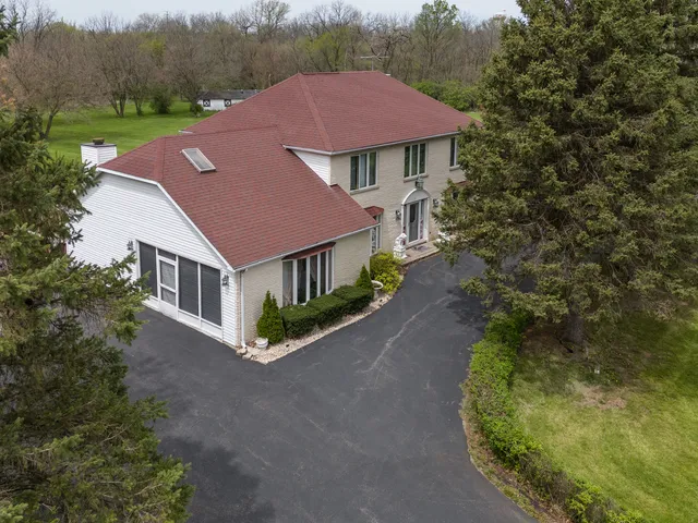 a aerial view of a house with yard and trees