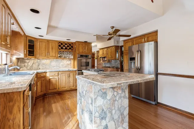 a kitchen with stainless steel appliances a stove a sink dishwasher and cabinets with wooden floor