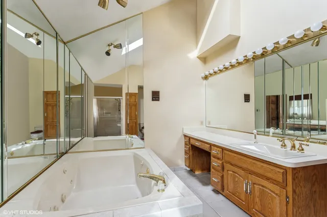 a bedroom with a bed a couch and a chandelier