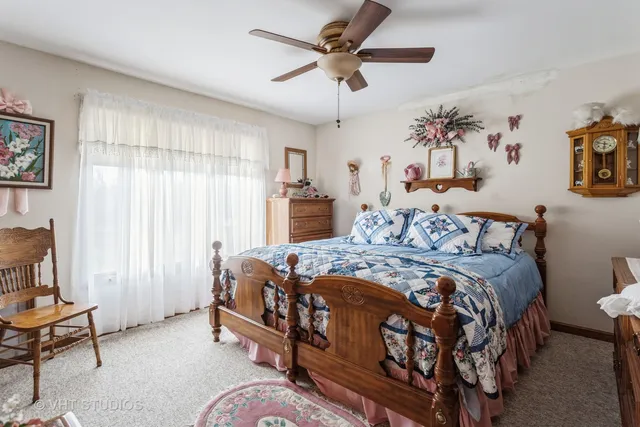 a bedroom with a bed a dresser and a chandelier