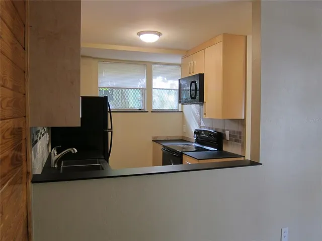 a kitchen with stainless steel appliances granite countertop a stove and a microwave