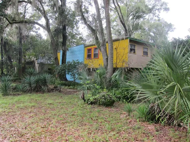 a front view of house with yard and trees around