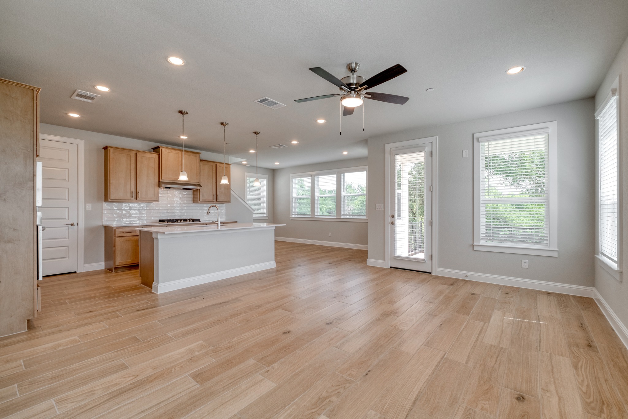 2605 Sam Bass Road, Unit 44 Round Rock, TX 78681 - Photo 5 of 26 An open-concept living space with warm wood flooring and a contemporary kitchen island.