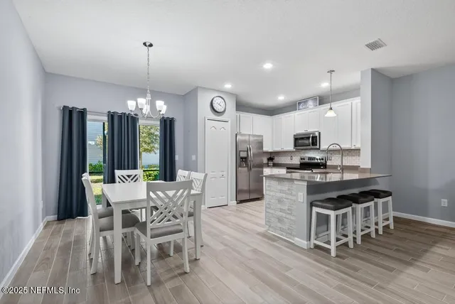 a view of a dining room with furniture wooden floor and chandelier