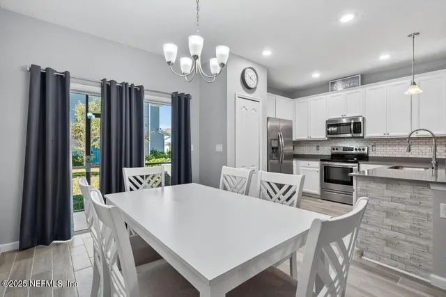 a large kitchen with kitchen island a stove a sink a refrigerator and a dining table