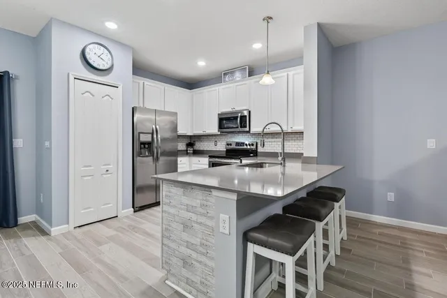 a kitchen with stainless steel appliances a stove a sink and a microwave