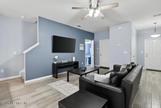 a living room with furniture a chandelier and a dining table