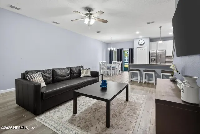 a kitchen with stainless steel appliances kitchen island granite countertop a dining table chairs and granite counter tops