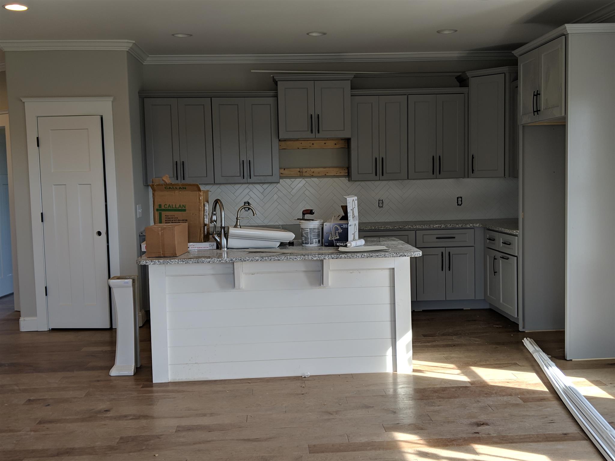 Kitchen w/ Breakfast Nook has beautiful gray custom cabinetry, granite countertops and center island