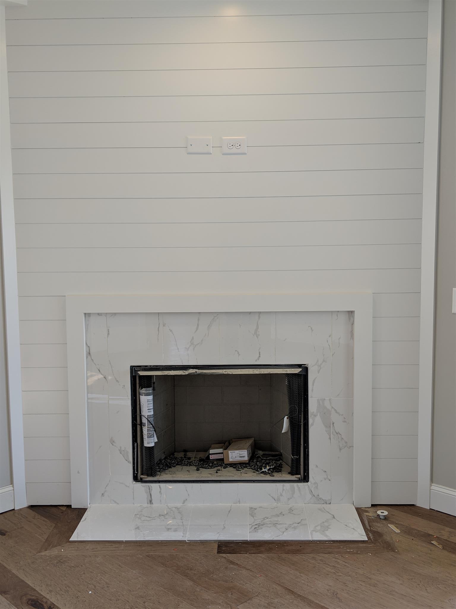 Family Room has gas fireplace w/ marble surround on shiplap wall