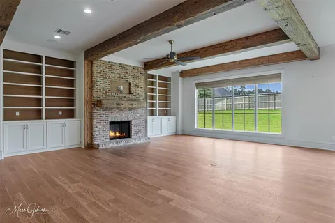 a view of an empty room with a window and fireplace