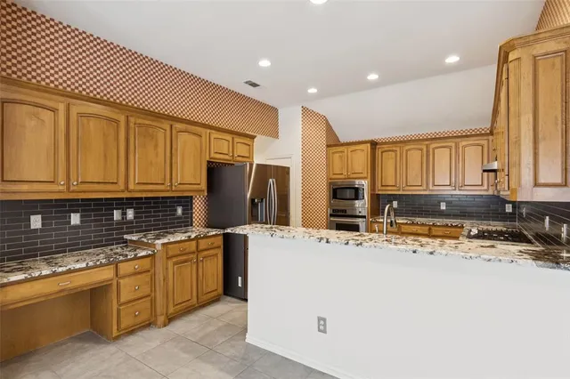 a kitchen with stainless steel appliances granite countertop a sink and cabinets
