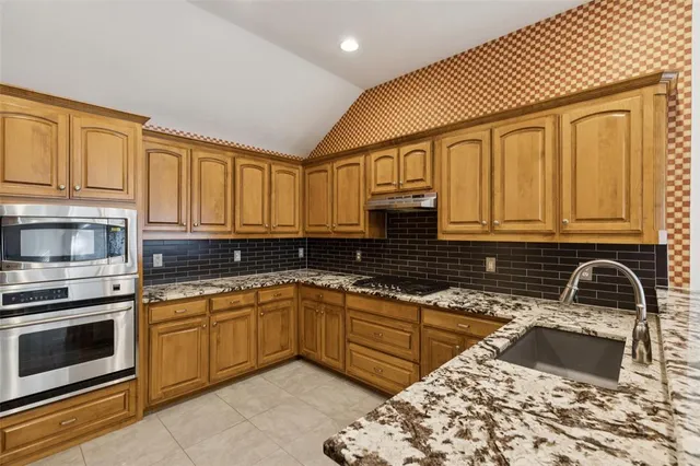 a kitchen with a sink stove and cabinets