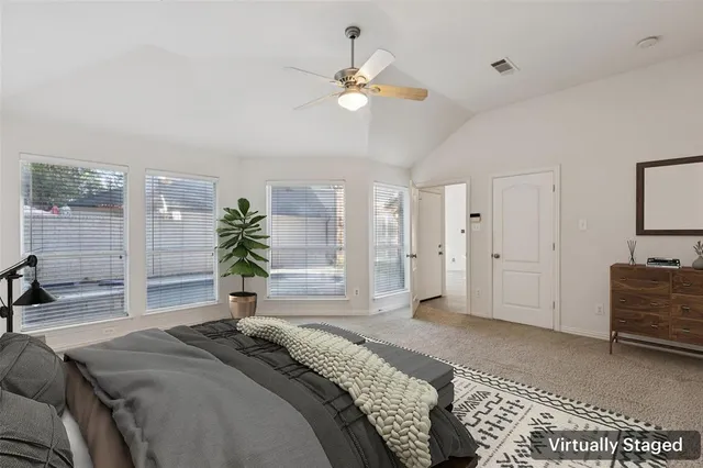 a bedroom with a large bed a chandelier and dresser