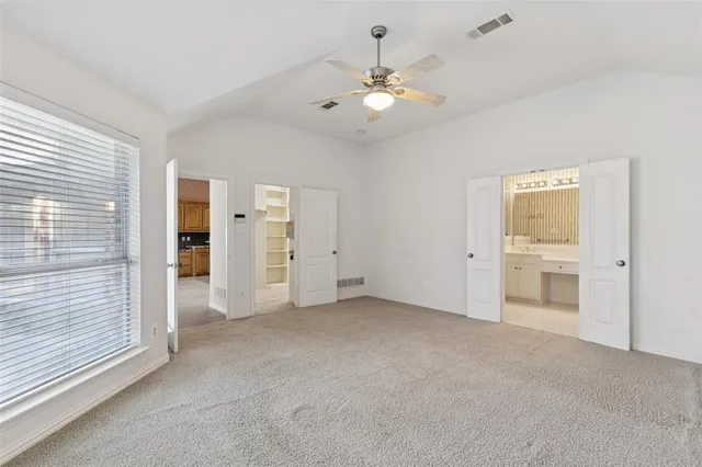 a view of a livingroom with a chandelier fan and windows