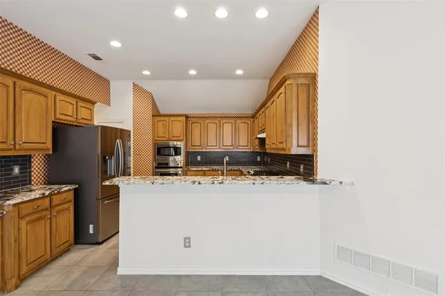 a kitchen with refrigerator a stove a sink and a microwave