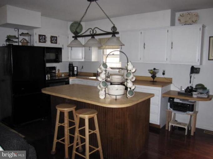 13240 Olivet Road Lusby, MD 20657 - Photo 4 of 24 a kitchen with a sink a stove and chairs