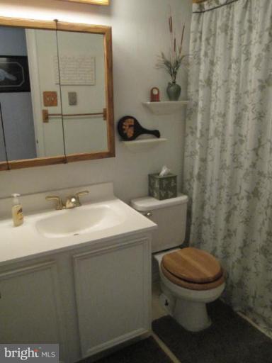 13240 Olivet Road Lusby, MD 20657 - Photo 9 of 24 a bathroom with a sink a toilet and mirror