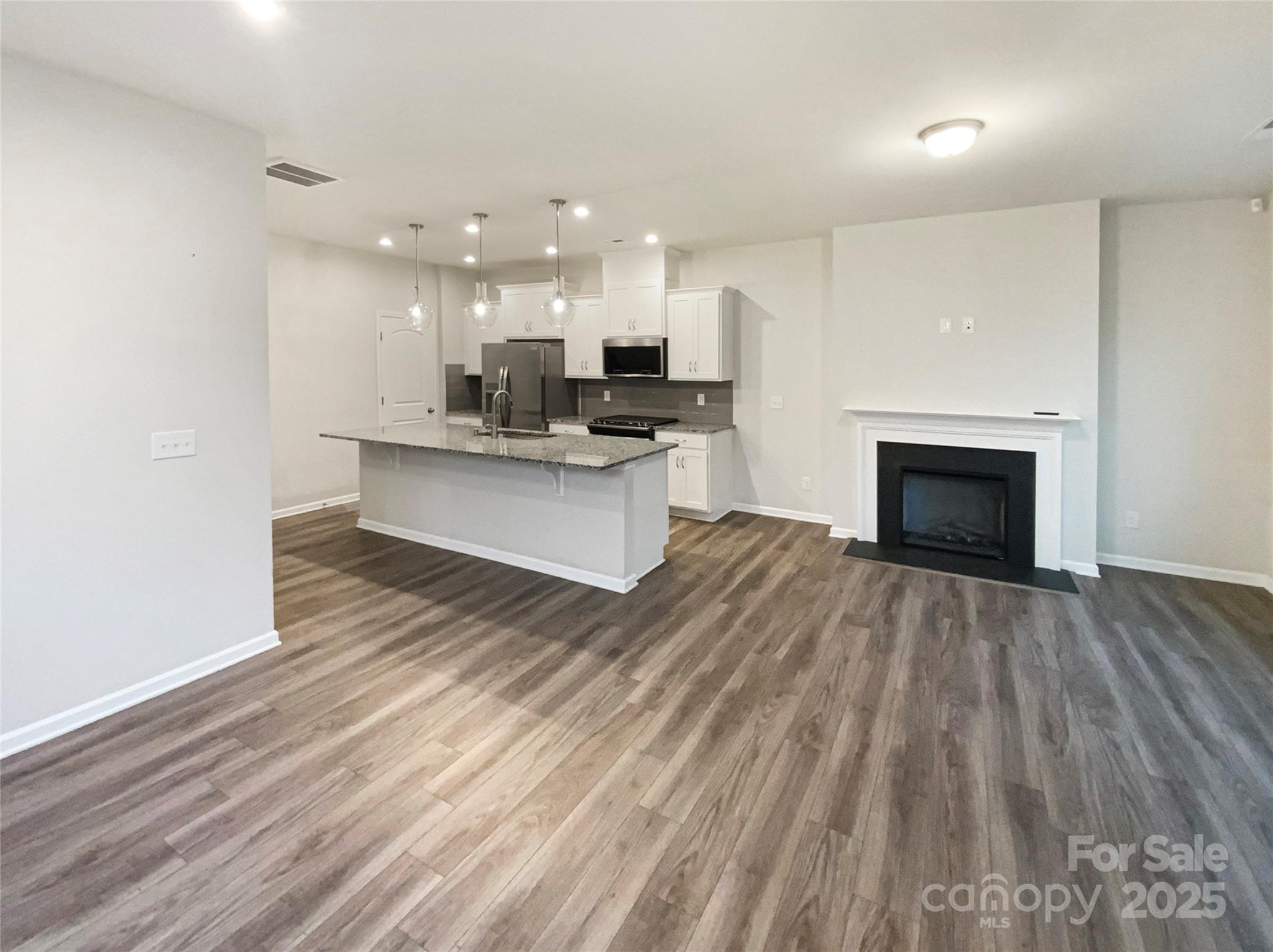 4105 Galloway Road Charlotte, NC 28262 - Photo 3 of 23 a living room with stainless steel appliances kitchen island hard wood floors and fireplace