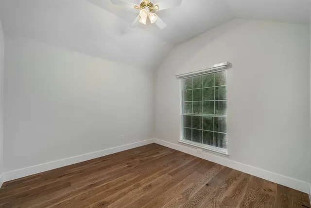 an empty room with wooden floor and a window