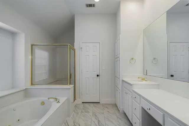 a bathroom with a tub sink and mirror