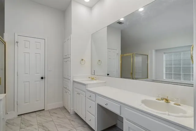 a spacious bathroom with a granite countertop sink and a mirror