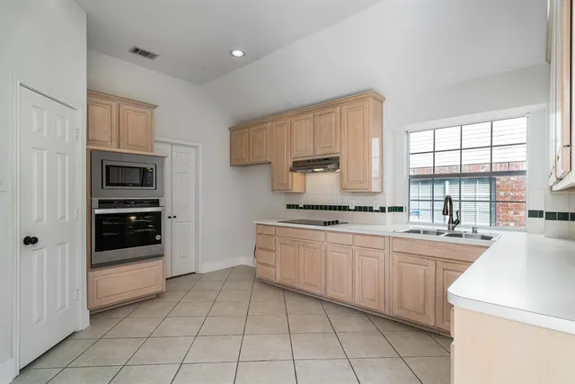 a kitchen with a sink window and cabinets