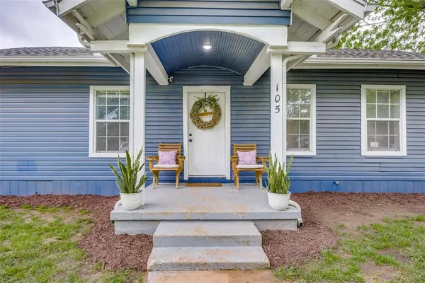 a view of brick house with potted plants