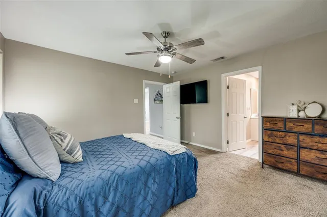 a spacious bedroom with a bed and a ceiling fan