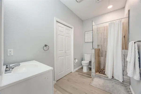 a bathroom with a sink a toilet and shower
