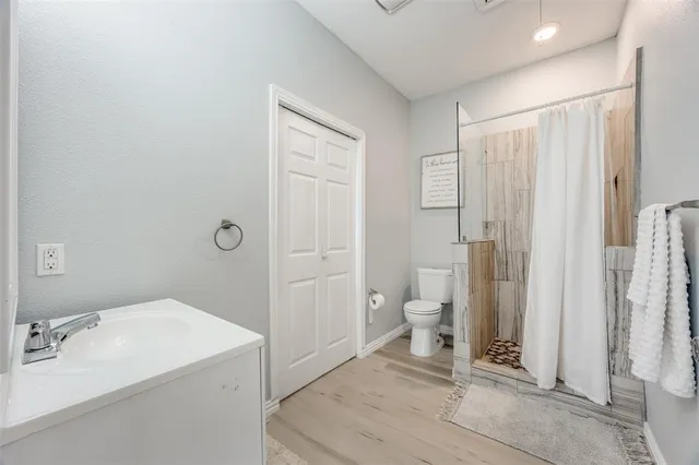 a bathroom with a sink a toilet and shower