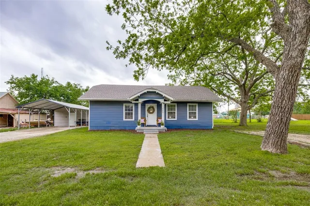 a front view of a house with yard and green space