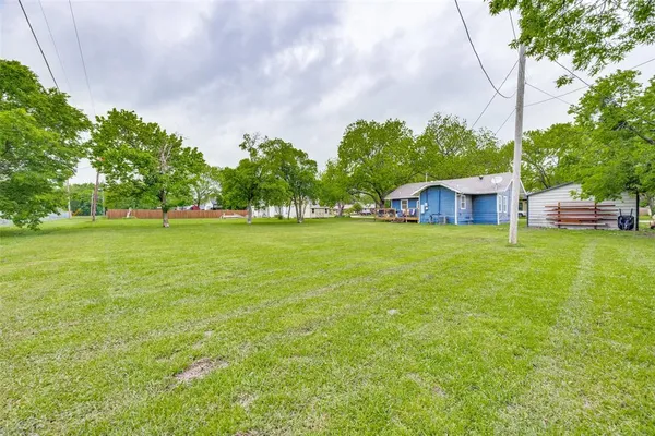 a view of a house with a big yard and large trees