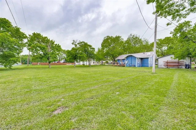 a view of a house with a big yard and large trees