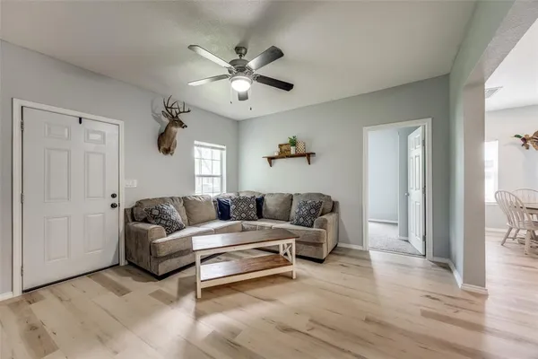 a living room with furniture and a wooden floor