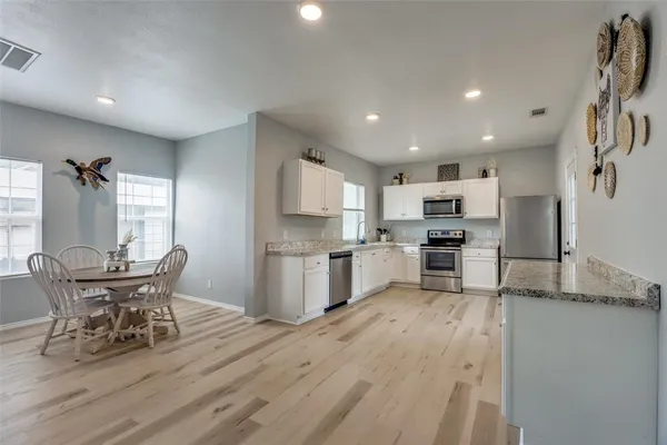 a kitchen with refrigerator cabinets and wooden floor