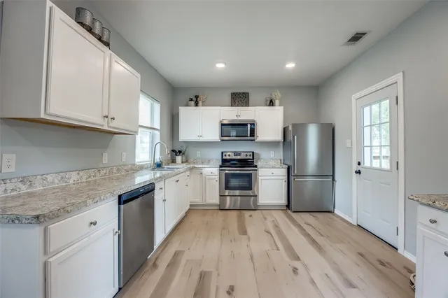 a kitchen with refrigerator a stove top oven and cabinets