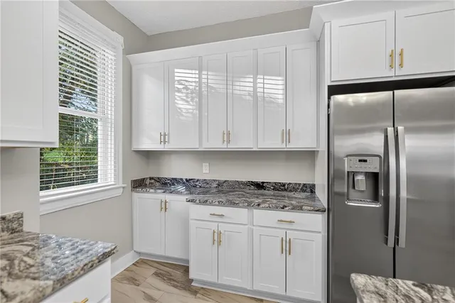 a kitchen with stainless steel appliances granite countertop a stove a refrigerator and a microwave