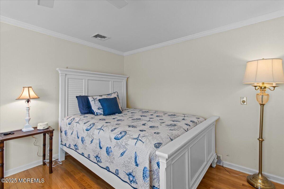 262 Sunset Lane Mantoloking, NJ 08738 - Photo 21 of 45 a bedroom with a bed and a lamp on the table