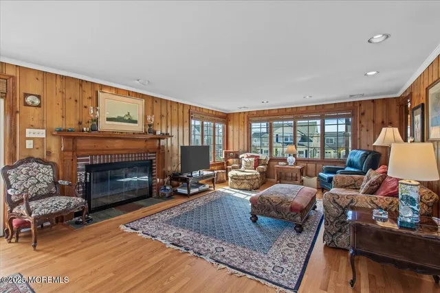 a living room with furniture a flat screen tv and a floor to ceiling window