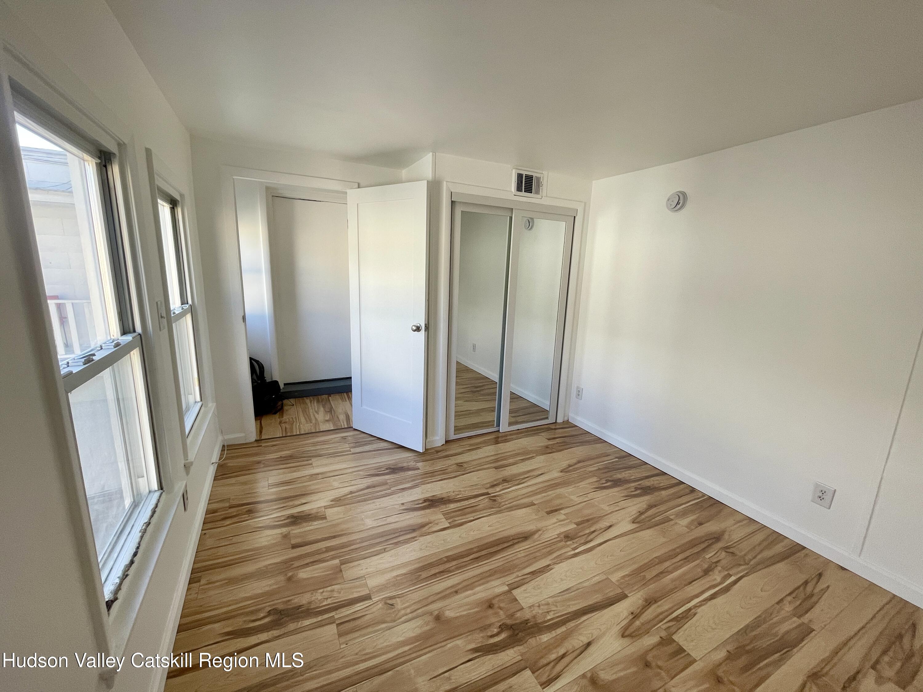 720 Warren Street, Unit 7 Hudson, NY 12534 - Photo 2 of 10 a view of an empty room with wooden floor and a window