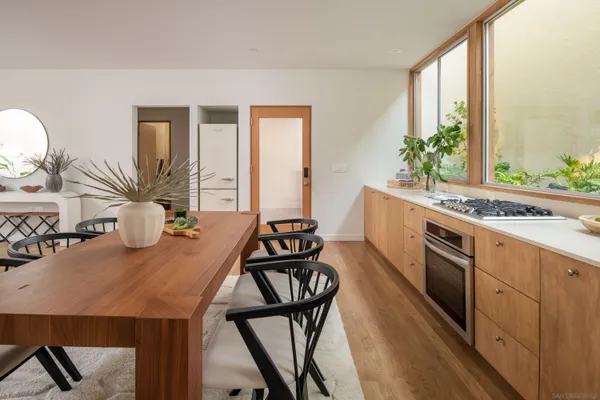 a kitchen with a table chairs stove and wooden floor