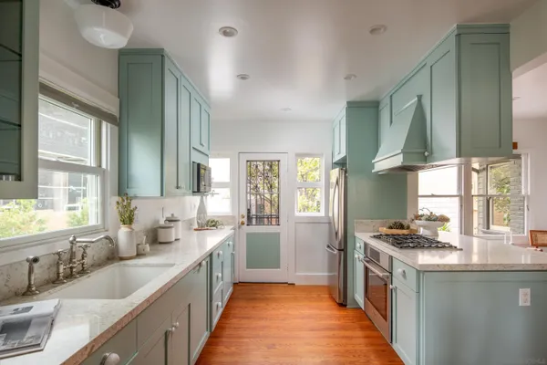 a kitchen with stainless steel appliances a sink stove and cabinets