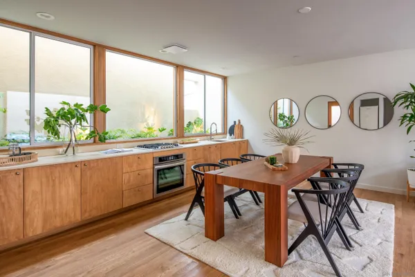 a kitchen with a table chairs a sink and a window