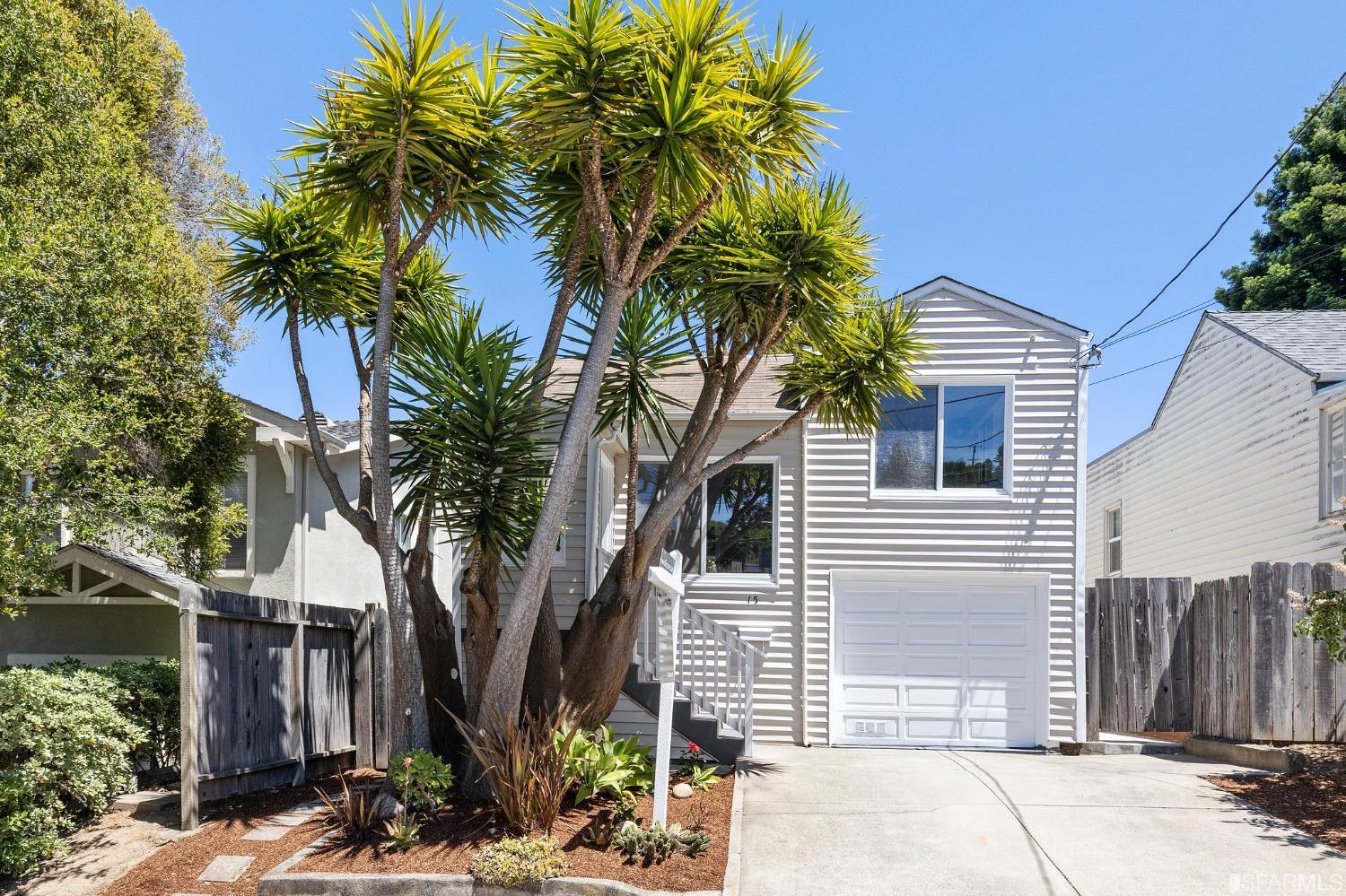 a palm tree sitting in front of a house