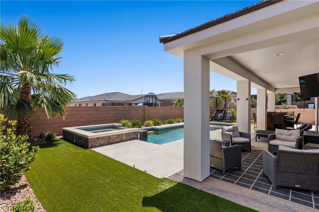 1436 Manassas Ridge Mesquite, NV 89027 - Photo 52 of 77 An inviting backyard oasis features a covered patio, refreshing pool, and relaxing spa.