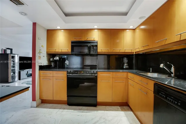 a kitchen with stainless steel appliances kitchen island granite countertop a stove a sink and a microwave