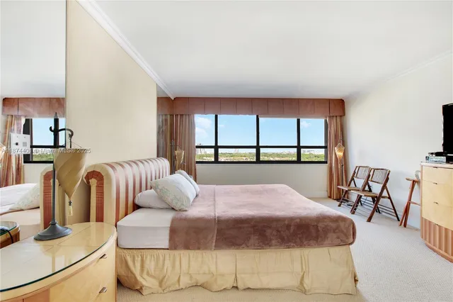 a bedroom with bed and a large window