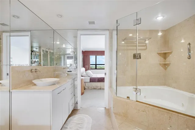 a spacious bathroom with a tub sink shower and mirror