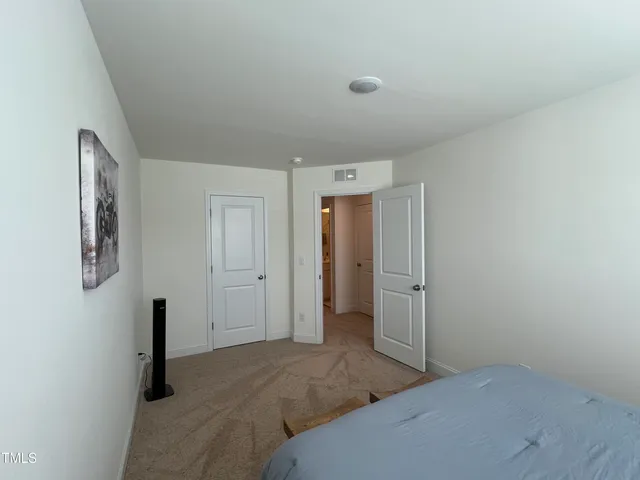 a bedroom with a bed and a painting on the wall